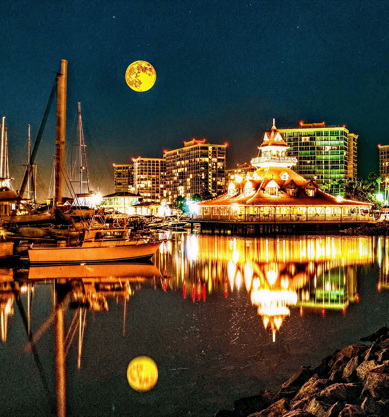 Boats docked under a full moon